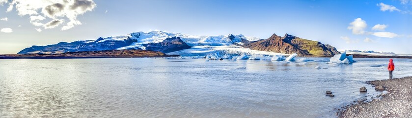 Fototapeta na wymiar Icelandic landscape. Panorama of tourist visiting the Fjallsarlon glacier and the lagoon at sunset.