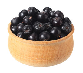 Chokeberry in wooden bowl isolated on white background. Black aronia