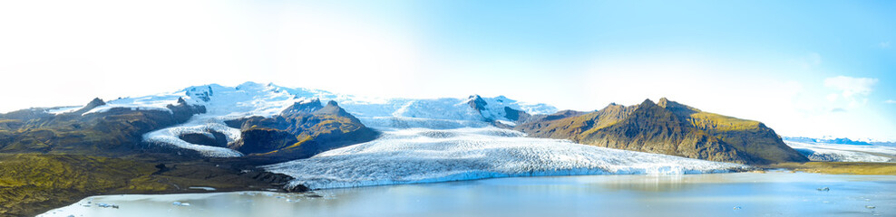Icelandic landscape. Panorama of tourist visiting the Fjallsarlon glacier and the lagoon at sunset.