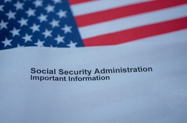 Fototapeta na wymiar Social Security Administration Important Information letter next to flag of USA. Above view
