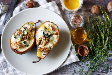 Baked pears with blue cheese, honey and herbs. French cuisine Appetizer to wine. Selective focus. Macro.