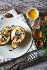 Baked pears with blue cheese, honey and herbs. French cuisine Appetizer to wine. Selective focus. Macro.