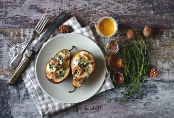 Baked pears with blue cheese, honey and herbs. French cuisine Appetizer to wine. Selective focus. Macro.