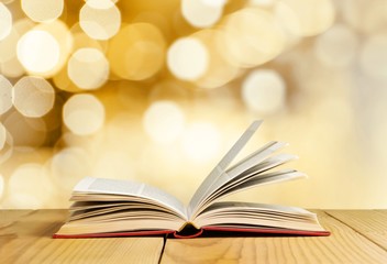 Open book on old wooden table.