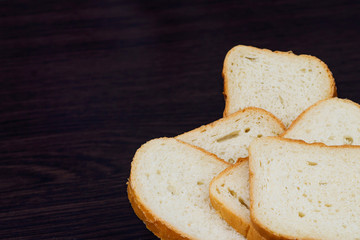 Sliced white bread on a brown background. Fresh homemade bread made from white flour. Pieces of bread.