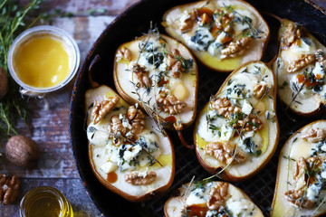 Baked pears with blue cheese, honey and herbs. French cuisine Appetizer to wine. Selective focus. Macro.