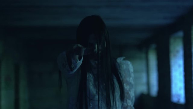 Psychotic dead bride holding out creepy hand in darkness, trying to catch victim