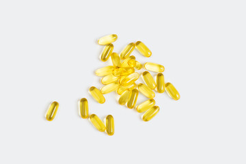 Pile of omega oil vitamin supplement pill soft gel capsules isolated on light gray background