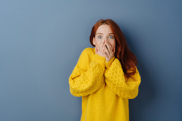 Shocked young woman with hands to mouth - obrazy, fototapety, plakaty