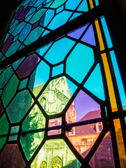 Blurred view of St. Paul's Cathedral in Liege, Belgium behind dirty colorful stained glass window, abstract picture