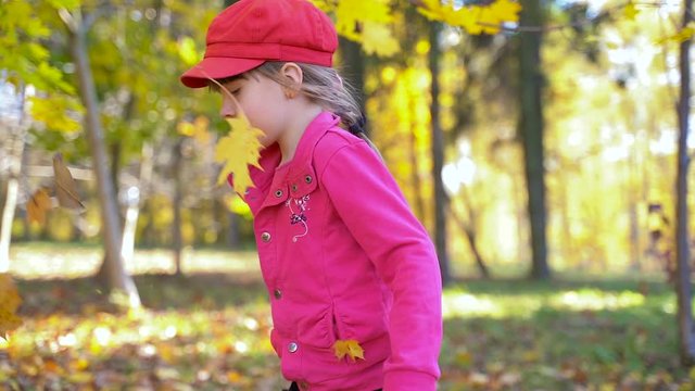 little girl in autumn park. slow motion