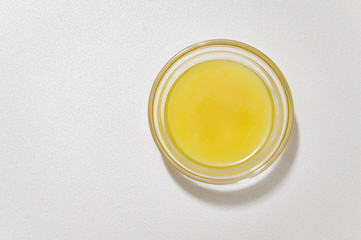 liquid butter in a glass bowls on a white textured background