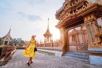 Crédence de cuisine en verre imprimé Bangkok Voyage par l& 39 Asie. Jeune femme au chapeau et robe jaune marchant près du temple bouddhiste de Chalong sur l& 39 île de Phuket en Thaïlande.