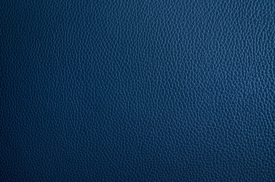 Leather texture close up. Dark blue fashionable background, top view. Stylish wallpaper of snake skin. Rough surface of navy blue color.