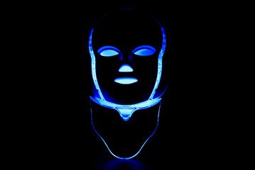 Color therapy mask glowing blue dark background