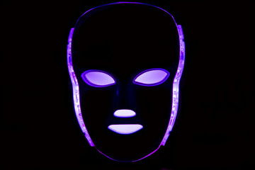 Color therapy mask glowing purple dark background
