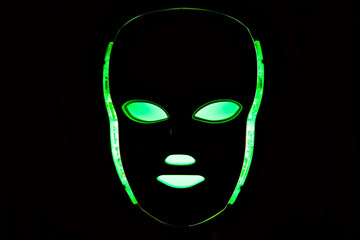 Color therapy mask glowing green dark background