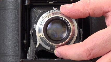 Man hand adjusts photo camera lens, preparing for shooting
