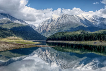 Reflection of the mountains on calm mission reservoir.
