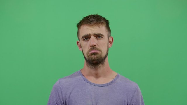 Facial Expression Of A Adult Man Pouting. Studio Isolated Shot Against Green Screen Background