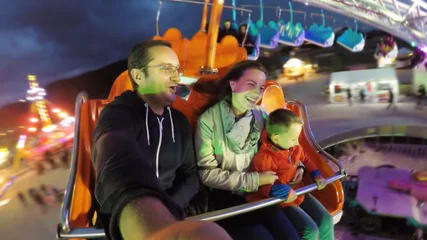 Photo sur Plexiglas Parc dattractions Parents and child having fun in amusement park, night entertainment