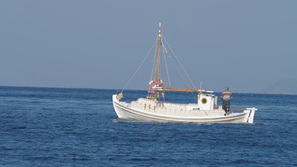 Fototapeta na wymiar Isolated white boat floating over blue sea water surface