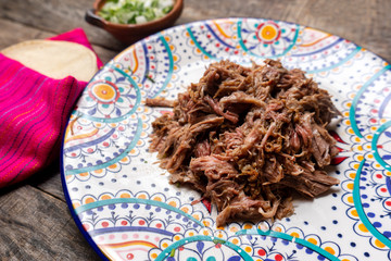 Mexican slow cooked lamb also called barbacoa on wooden background © Guajillo studio