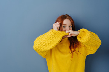 Playful woman pulling at the sleeve of a sweater