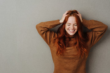 Happy young woman running hands through her hair