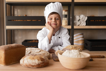 Dreamy little baker working in store