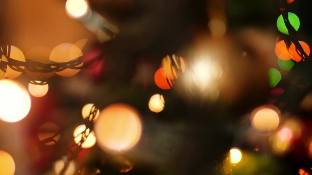 Closeup abstract video of glowing and sparkling light garland on Christmas tree