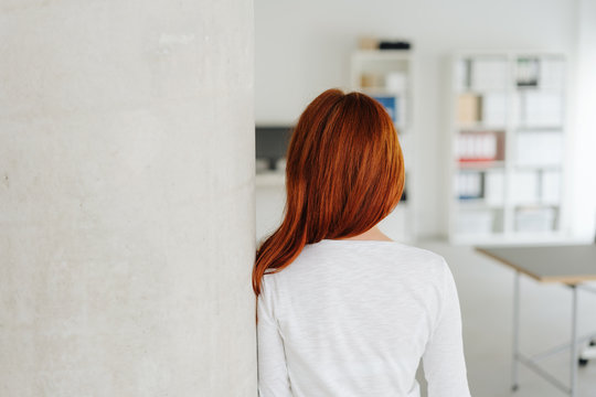 Rear view of a redhead woman in an office