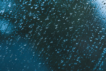 heavy rain drops on blue window