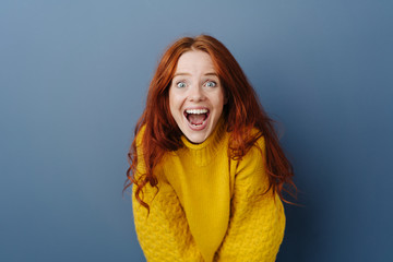 Laughing delighted young woman leaning forwards