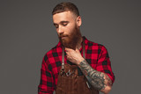 Stylish barber touching ginger beard