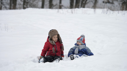 Children play with snow together, beautiful childhood with brother