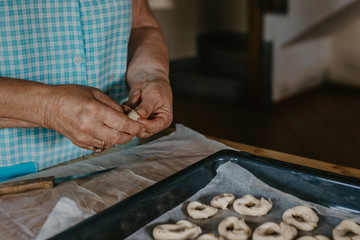 Fototapeta na wymiar woman hands preparing sweets or donuts with traditional recipe at home