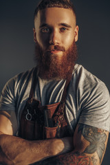 Confident bearded barber looking at camera