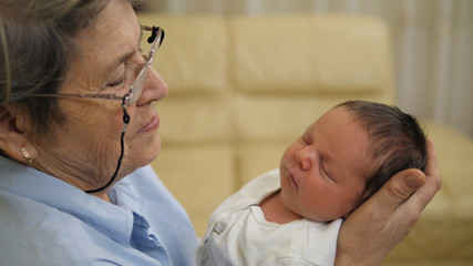 Fototapeta premium Portrait of old grandmother and young newborn baby, past and future together