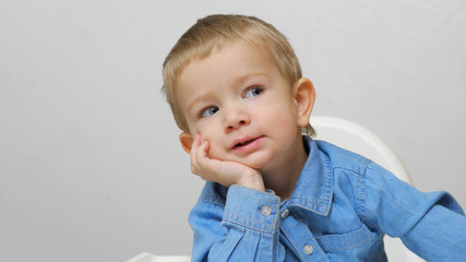 Lovely blue eyes child portrait  hold head on hands, boy screaming