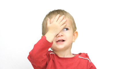 Portrait of funny child covering one eye with hand, medical exam