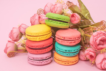 tasty colorful macarons on pink background