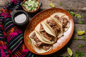 Mexican slow cooked lamb tacos also called barbacoa on wooden background