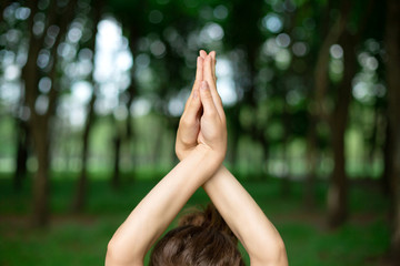 A young sports girl practices yoga in a quit green summer forest, yoga assans posture. Meditation...