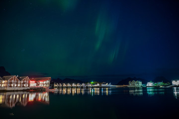 Traditional houses with northern lights in Lofoten, Norway