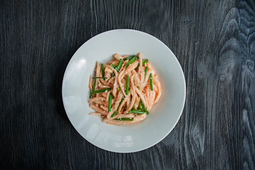 Salad with daikon radish, green onions, honey and red chili powder. Flat lay. Space for text. Dark background.
