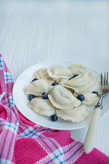 Dumplings with fruits on a white plate. White background . Traditional dish of Ukraine.
