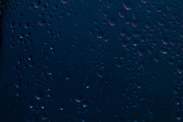 Raindrops on the surface of window panes Natural pattern of raindrops, on a blue background.