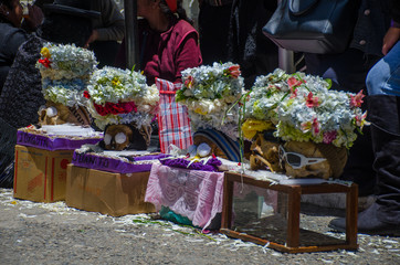 The photograph shows several human skulls in a Bolivian festival where death is venerated