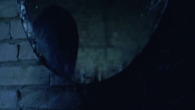 Cruel witch stabbing victim with knife for sacrifice ritual, mirror reflection